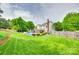 Expansive backyard featuring a pristine lawn, mature trees, manicured landscaping and a pool creating a private oasis at 15306 Gower Ct, Charlotte, NC 28278