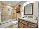 Modern bathroom with granite counters, wood cabinets, a shower, and neutral tile at 15306 Gower Ct, Charlotte, NC 28278