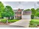 Traditional two-story home with brick and siding, a well-manicured lawn, and a spacious driveway leading to a garage at 15306 Gower Ct, Charlotte, NC 28278