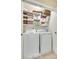 Laundry room equipped with a washer, dryer, and shelving for organized storage of cleaning supplies at 15306 Gower Ct, Charlotte, NC 28278