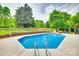 Sparkling backyard pool with concrete surround, mature trees, and well-maintained landscaping at 15306 Gower Ct, Charlotte, NC 28278