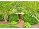 Charming shed nestled amidst lush greenery and manicured bushes, accessed by a brick pathway, offering storage at 15306 Gower Ct, Charlotte, NC 28278