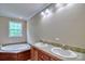 Bathroom with double vanity, bright window and soaking tub at 1774 Wintertide Rd, Jefferson, SC 29718