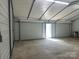 Large metal garage with a roll-up door, offering versatile storage options with durable concrete flooring and lighting at 1774 Wintertide Rd, Jefferson, SC 29718