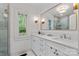 Bright bathroom features double vanity, large mirror, tiled shower and window at 1933 Thurmond Pl, Charlotte, NC 28205