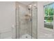 Bathroom features a glass enclosed marble tiled shower and bright window at 1933 Thurmond Pl, Charlotte, NC 28205