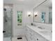 Bathroom features double vanity, large mirror, tiled shower and a window at 1933 Thurmond Pl, Charlotte, NC 28205