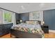 Bedroom with navy accent wall, hardwood floors and two bright windows at 1933 Thurmond Pl, Charlotte, NC 28205