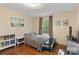 Cozy bedroom with hardwood floors, a comfortable bed, reading nook, and ample natural light at 1933 Thurmond Pl, Charlotte, NC 28205