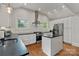 Well-lit kitchen with white cabinetry, stainless steel appliances, and a tile backsplash at 1933 Thurmond Pl, Charlotte, NC 28205