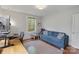 Cozy office space featuring a blue sofa, ergonomic chair, and natural lighting from the window at 1933 Thurmond Pl, Charlotte, NC 28205