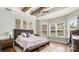 A bright bedroom featuring wooden ceiling beams, and a cozy bed with a gray headboard at 1963 Felts Pkwy, Fort Mill, SC 29715