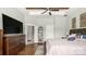 A well-lit bedroom with ensuite bathroom access, ceiling fan, and a stylish dark-wood dresser at 1963 Felts Pkwy, Fort Mill, SC 29715