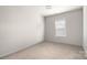 A simple and neutral bedroom with a single window and carpeted floors at 1963 Felts Pkwy, Fort Mill, SC 29715