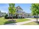 Beautifully landscaped front yard with a two-story home featuring a welcoming porch and an attached two-car garage at 1963 Felts Pkwy, Fort Mill, SC 29715