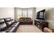 A cozy living room with comfortable leather sofas, bay window, and a modern entertainment center at 1963 Felts Pkwy, Fort Mill, SC 29715