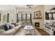 Comfortable living room with fireplace, large windows, and hardwood floors at 1963 Felts Pkwy, Fort Mill, SC 29715