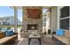 Comfortable seating sits on the screened porch with a brick fireplace at 1963 Felts Pkwy, Fort Mill, SC 29715