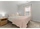 Cozy bedroom showcasing soft, neutral tones, a plush bed, and natural light from the window at 2037 Birchside Dr, Charlotte, NC 28205