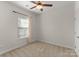 A bright bedroom with neutral walls, carpet, a ceiling fan and a large window at 2037 Birchside Dr, Charlotte, NC 28205