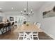 Open dining area with a wooden table, chandelier, and seamless access to the kitchen and living room at 2037 Birchside Dr, Charlotte, NC 28205
