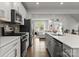 Bright kitchen with stainless appliances, white cabinets, island sink, and open floor plan to living space at 2037 Birchside Dr, Charlotte, NC 28205