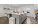 Modern kitchen featuring a large island with white countertop, stainless steel sink, and dining area with chandelier at 2037 Birchside Dr, Charlotte, NC 28205