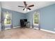 Bedroom with light blue walls, carpeted floor, ceiling fan, and windows with sheer curtains on either side of the room at 204 Millwheel Ln, Mount Gilead, NC 27306
