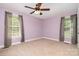 Bedroom with lilac walls, carpeted floor, a ceiling fan, and windows with sheer curtains on either side of the room at 204 Millwheel Ln, Mount Gilead, NC 27306
