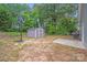 Spacious backyard featuring a basketball hoop, storage shed, and concrete pad, ideal for outdoor activities at 205 E Maine Ave, Bessemer City, NC 28016