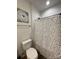 This bathroom features patterned shower curtains, a toilet, vinyl floors, and a granite vanity at 205 E Maine Ave, Bessemer City, NC 28016