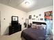 Cozy bedroom featuring a dark-colored bed frame, dresser with TV, and plush pillows at 205 E Maine Ave, Bessemer City, NC 28016