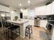 Well-lit kitchen with white cabinets, hardwood floors, and a center island with barstools at 205 E Maine Ave, Bessemer City, NC 28016