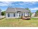 Backyard features a small deck and lush lawn, surrounded by trees and a white picket fence at 2111 Savoy Pl, Fort Mill, SC 29707