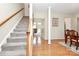 Inviting foyer featuring hardwood floors, a staircase with carpet runner, and a view into the living spaces at 2111 Savoy Pl, Fort Mill, SC 29707