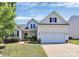 Charming two-story home with a well-manicured lawn, blooming flowerbeds, and a two-car garage at 2111 Savoy Pl, Fort Mill, SC 29707