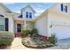 Charming home exterior featuring a well-manicured lawn, flower beds, and a welcoming entrance with a decorative wreath at 2111 Savoy Pl, Fort Mill, SC 29707
