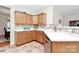 Efficient kitchen featuring wood cabinetry, neutral countertops, tile backsplash and stainless steel dishwasher at 2111 Savoy Pl, Fort Mill, SC 29707