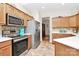 Updated kitchen with stainless steel appliances, wood cabinetry and backsplash, and tile flooring at 2111 Savoy Pl, Fort Mill, SC 29707