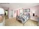 A bright bedroom featuring pink walls, neutral carpet, and stylish bedside tables at 215 Giant Oak Ave, Statesville, NC 28677