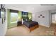Well-lit bedroom featuring windows with views, neutral carpet, and light green accent wall with sports décor at 215 Giant Oak Ave, Statesville, NC 28677