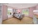 A bright bedroom featuring pink walls, neutral carpet, and a large window for ample natural light at 215 Giant Oak Ave, Statesville, NC 28677