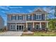 Two story home featuring gray siding, stone accents, dark shutters and an inviting front porch at 215 Giant Oak Ave, Statesville, NC 28677