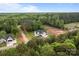 Expansive aerial view of a newly built home surrounded by lush greenery, mature trees, and a construction site nearby at 2336 Beth Haven Church Rd, Denver, NC 28037
