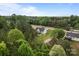 Picturesque aerial view of a white house nestled among tall trees with a long driveway leading to the street at 2336 Beth Haven Church Rd, Denver, NC 28037