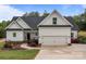 Charming home with a two-car garage, walkway lined with colorful flowers, and manicured lawn at 2336 Beth Haven Church Rd, Denver, NC 28037