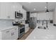 Well-lit kitchen features stainless steel appliances, stylish white cabinets, and a quartz countertop island at 2336 Beth Haven Church Rd, Denver, NC 28037