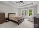 Serene main bedroom with tray ceilings, plush carpet, and a cozy sitting area bathed in natural light at 2336 Beth Haven Church Rd, Denver, NC 28037
