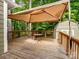 This outdoor deck with canopy provides a perfect spot for relaxation, dining, and enjoying nature's beauty at 2731 Creekbed Ln, Charlotte, NC 28210