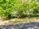 A cozy home surrounded by lush greenery, showcasing its inviting exterior and curb appeal at 2731 Creekbed Ln, Charlotte, NC 28210